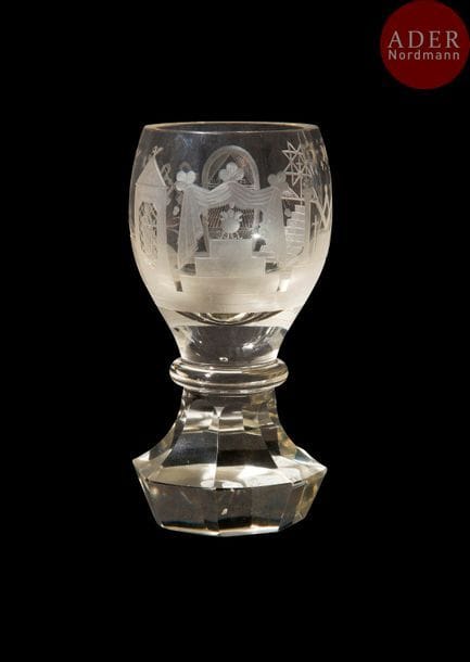 Verre dit « canon » maçonnique en verre taillé, gravé, rond, sur pied à neuf pans, gravé de décors symboliques, épées croisées, clés croisées, triangle, truelle, colonnes, maillet, niveau, perpendiculaire, plumes croisées, compas, 7 marches, triple triangle orné au centre d’une croix.
Hauteur. : 15 cm
B.E. XXe siècle