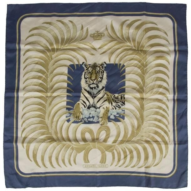 Carré Hermès, modèle Le tigre royal, en twill de soie, à décor d un tigre, fond blanc, entourage bleu (taches).