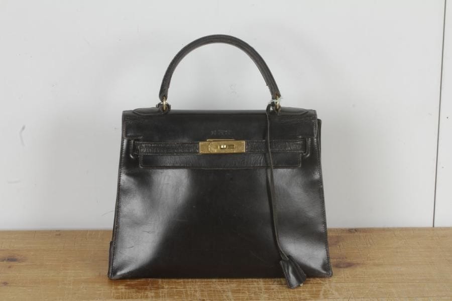 HERMES. Sac Kelly en box noir. Larg. : 28 cm - Hauteur : 22 cm. Usures et chiffres piqués au dessus du fermoir. Cadenas non signé, clés.