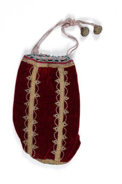 SAC À TEFILIN (?) - Velours rouge formant un tube cylindrique souple et velours vert formant la base, le tout brodé de fils métalliques dorés formant une étoile à six branches à la base. Glands de passementerie. Pas d'inscription. Haut.: 25 cm. Diam.: 12 cm. Afrique du Nord (Maroc ?) début du XX ème siècle.