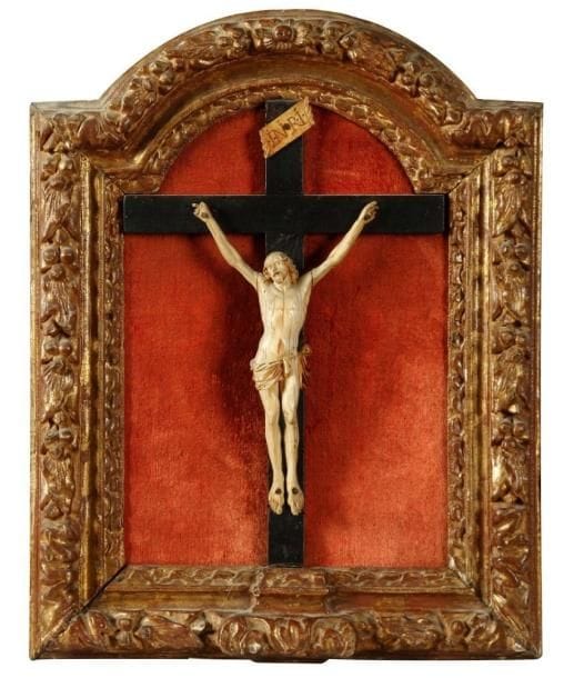 Christ en ivoire dieppois dans son cadre du XVIIIe siècle. Le Christ du XVIIIe siècle est caractéristique du travail des ivoiriers dieppois et il est présenté dans un cadre en bois sculpté et doré du début du XVIIIe siècle. Manquent quelques doigts du christ. Hauteur totale : 41 cm, le Christ 18,5 cm.
