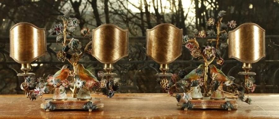 Paire de candélabres à deux lumières, en bronze ou laiton doré à décor de branchages fleuris et feuillagés à fleurettes en porcelaine ou pâte tendre. Au centre des oiseaux. Style du XVIIIe siècle. Hauteur : 32 cm - Largeur : 28 cm.
