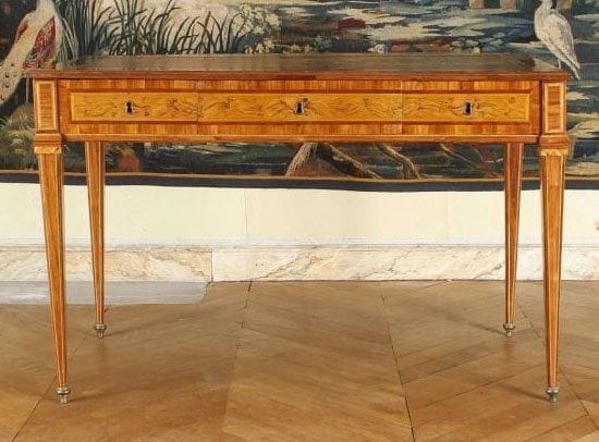 Bureau en placage de bois de rose marqueté sur des fonds de citronnier de branchages fleuris et feuillagés.  Il ouvre par un rang de trois tiroirs sans traverse. Travail italien, de la fin du XVIIIe siècle (restaurations). Plateau de cuir beige doré aux petits fers. Hauteur : 79 cm - Largeur : 123 cm - Profondeur : 62 cm.