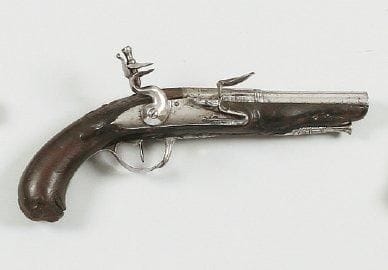 Pistolet à silex. Canon rond à pans au tonnerre. Platine et chien col de cygne à corps rond. Garnitures en fer. Crosse en noyer sculpté. B.E. Vers 1780.