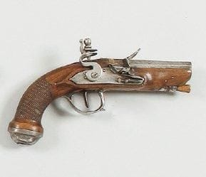 Pistolet de voyage à silex. Canon à pans, gravé. Platine et chien col de cygne à corps plat. Garnitures en fer. Crosse en noyer quadrillé. Baguette en bois. B.E. Vers 1780.