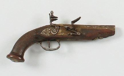 Pistolet à silex. Canon à pans. Platine et chien à corps plat gravés, bassinet et garnitures en fer. Crosse en noyer quadrillé. A.B.E. Vers 1800-1820. (Manque la baguette).