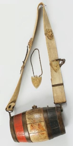 Tonneau de cantinière. En bois peint tricolore, à l'aigle. Peint «M. Met. Cantinière.» et «81e de ligne.» Bretelle en cuir blanchi. Garnitures en laiton. B.E. On y joint un motif de bretelle à l'Aigle.