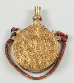Poire à poudre marocaine. Ronde, en laiton et argent ciselé, à deux anneaux de suspente. XXe siècle.