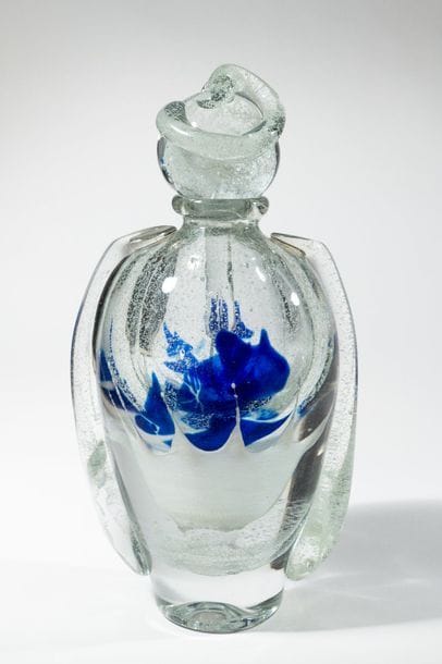 Jean-Claude NOVARO (1943-2015)
 Flacon ovoïde en verre soufflé transparent à décor bullé luminescent, émail bleu en partie centrale. Anses rapportées sur le corps et le bouchon.


Signé et daté 2008 sous la base.


Hauteur : 32 cm.