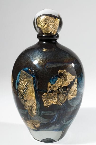 Jean-Claude NOVARO (1943-2015)
 Flacon ovoïde en verre soufflé, inclusion d’oxydes métalliques noir et bleu, cordons internes de feuilles d’or.


Signé et daté 2004 sous la base.


Hauteur : 30 cm.