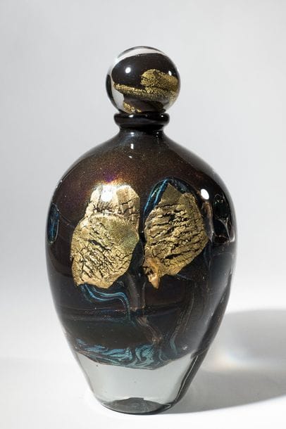 Jean-Claude NOVARO (1943-2015)
 Flacon ovoïde en verre soufflé, inclusion d’oxydes métalliques bleu et noir, cordons internes de feuilles d’or.


Signé et daté 2004 sous la base.


Hauteur : 31 cm