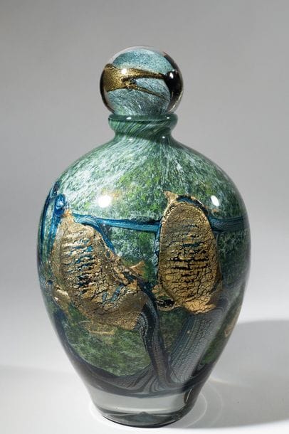 Jean-Claude NOVARO (1943-2015)
 Flacon ovoïde en verre soufflé, inclusion d’oxydes métalliques vert et bleu, cordons internes de feuilles d’or.


Signé et daté 2004 sous la base.


Hauteur : 31 cm.