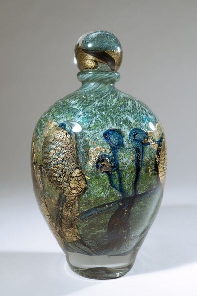 Jean-Claude NOVARO (1943-2015)
  Flacon ovoïde en verre soufflé, inclusion d’oxydes métalliques vert, gris et bleu, cordons internes de feuilles d’or.


Signé et daté 2004 sous la base.


Hauteur : 26 cm.