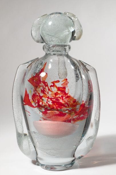Jean-Claude NOVARO (1943-2015)
 Flacon ovoïde en verre soufflé transparent à décor bullé luminescent, émaux rouge en partie centrale. Anses rapportées sur le corps et le bouchon.


Signé et daté 2008 sous la base.


Hauteur : 30 cm.