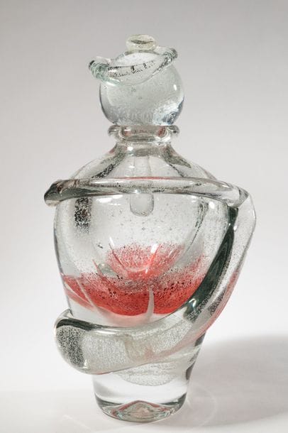 Jean-Claude NOVARO (1943-2015)
 Flacon ovoïde en verre soufflé transparent à décor bullé luminiscent, émaux rouge en partie centrale. Cordon librement rapporté sur le corps et le bouchon.


Signé et daté 2008 sous la base.


Hauteur : 31 cm.