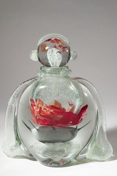 Jean-Claude NOVARO (1943-2015)
 Flacon boule en verre soufflé transparent à décor bullé luminescent, émaux orange et rouge en partie centrale. Anses rapportées sur le corps et le bouchon.


Signé et daté 2008 sous la base.


Hauteur : 33 cm.