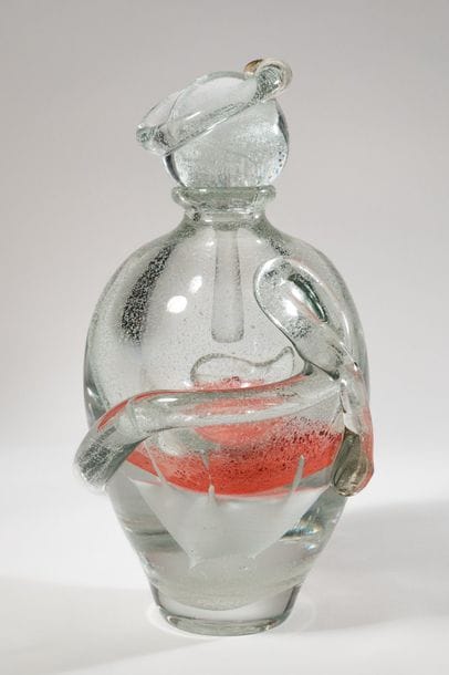 Jean-Claude NOVARO (1943-2015)
 Flacon ovoïde en verre soufflé transparent à décor bullé luminescent, émaux rouge en partie centrale. Cordon librement rapporté sur le corps et le bouchon.


Signé et daté 2008 sous la base.


Hauteur : 30 cm.