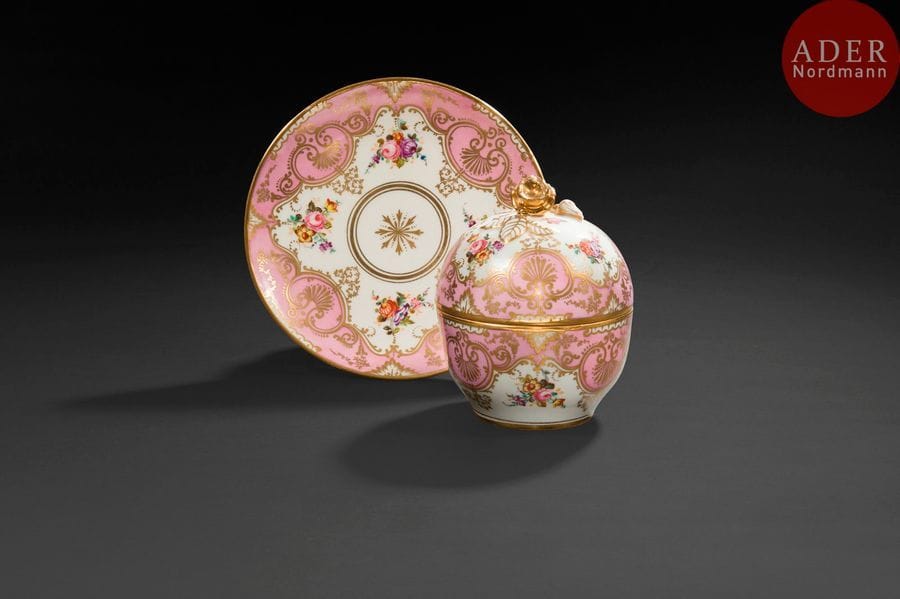 Sèvres (genre de)
Boite ronde couverte et plateau circulaire à décor polychrome de fleurs sur fond partiel rose.
Marque apocryphe de Sèvres.
Fin du XIXe siècle. 
H : 17 cm