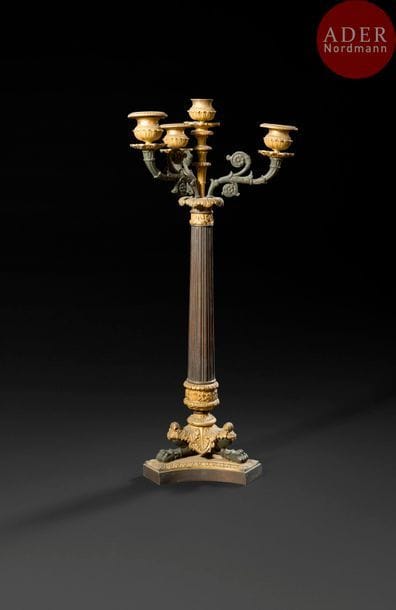 Candélabre en bronze patiné et doré, le fût en tôle repoussée à cannelures supportant quatre lumières, reposant sur un piétement tripode en jarret.
Époque Louis-Philippe 
H : 50 cm