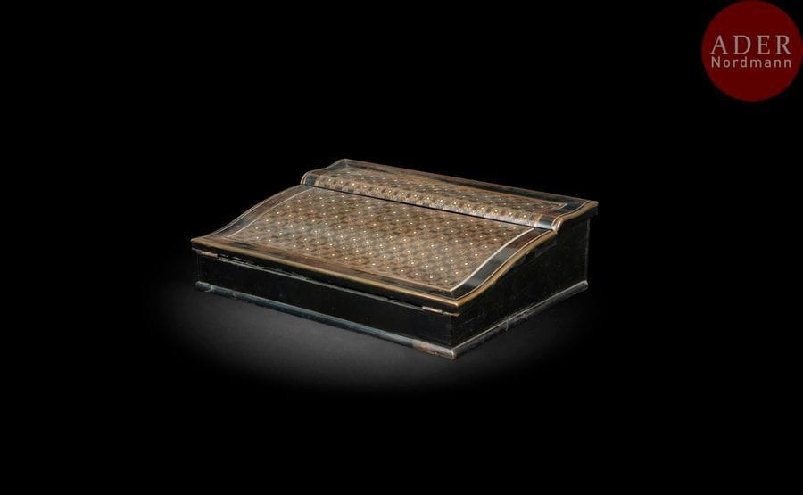 écritoire en marqueterie de laiton sur fond de bois noirci, à décor de rosette, ouvrant à un abattant et un compartiment à écrire.
Signe de la maison Tahan à Paris
Époque Napoléon III (accidents et manques)
H : 6 cm, L : 33 cm, P : 25 cm