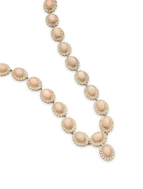Collier en or 18K (750), articulé de 20 motifs ovales, chacun serti d’un corail cabochon entouré de diamants. 
Longueur : 39,5 cm environ. 
Poids brut : 92,3 g