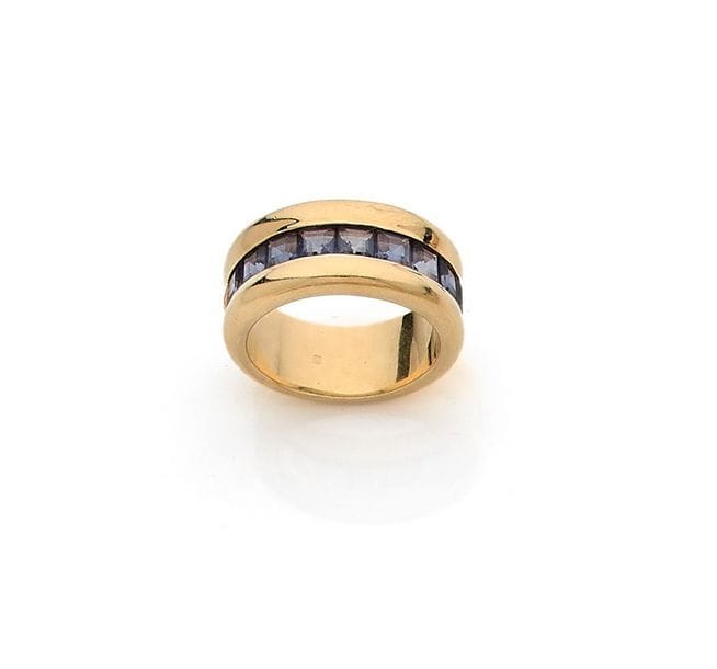 POIRAY
Large bague en or 18K (750) sertie d’une ligne de 9 tanzanites calibrées. Signée et numérotée. Dans son écrin. Tour de doigt : 54. 
Poids brut : 14,2 g