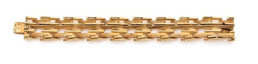 HERMÈS
Bracelet en or 18K (750), articulé de maillons allongés lisses et guillochés se chevauchant. Signé et numéroté. Travail français des années 1970. Dans son écrin. 
Dimensions : 2 x 17,3 cm environ. 
Poids : 88 g