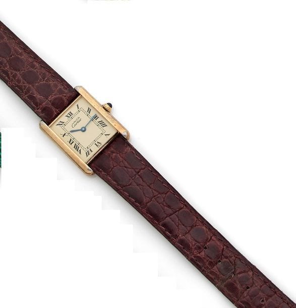 CARTIER Must
Montre de dame en vermeil, modèle Tank, fond crème, index chiffres romains, remontoir en saphir cabochon. Signée et numérotée.
