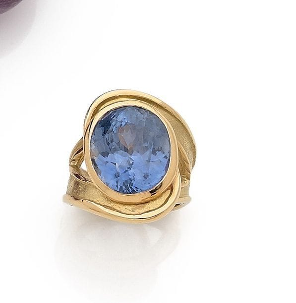 HÉLÈNE COURTAIGNE DELALANDE
Bague en or 18K (750) nouée, modèle Tornade, sertie d’un saphir de forme ovale pesant 16,1 cts. Non signée, poinçon de maître. Tour de doigt : 51. 
Poids brut : 17,6 g

La bague accompagnée de sa facture d’achat.