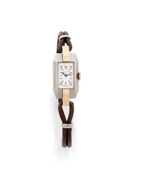 CARTIER vers 1930
Montre bracelet pour femme de forme rectangulaire en or 18K (750) et acier, cadran blanc index appliqués formant les heures. Mouvement à remontage mécanique signé EWC, fond de boîte et lunette ainsi que la boucle déployante portent le même numéro (2). Bracelet cuir avec sa boucle déployante numérotée.
Poids brut : 15,3 g 