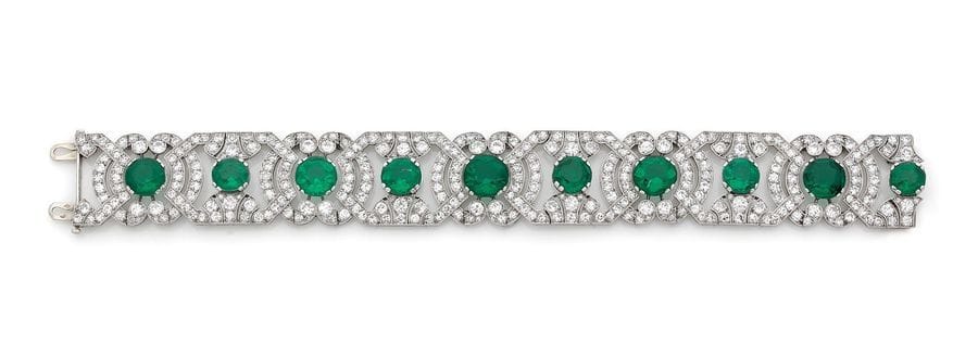 JANESICH
Bracelet en platine, articulé de motifs géométriques quadrangulaires ou arrondis altérnés, imbriqués sertis de diamants ronds, chaque maillon centré d’une pierre verte synthétique. Signé et numéroté. Travail français des années 1925. Dimensions : 2,2 x 18,5 cm environ.
Poids brut : 52,7 g (cliquet en or gris 18K)

Leopoldo Janesich (date de naissance indéterminée-1880) ouvre sa propre maison de joaillerie à Trieste en 1835 où il fournit rapidement les plus grandes familles triestines. Son travail se caractérise par des lignes classiques très en vogue à l’époque. L’entreprise florissante est ensuite dirigée par son fils Giovanni qui l’ouvre à l’international en créant une succursale à Paris. C’est là qu’il installe son fils Alberto. Ce dernier noue des relations avec les plus grands noms de la joaillerie de l’époque, et donne une nouvelle dynamique, tant en France qu’à l’étranger. La réputation de la Maison Janesich est mondiale. Des boutiques sont ouvertes en Italie, en Angleterre et en France, notamment à Paris rue de la Paix. Le succès est au rendez-vous, les créations des années 1920-1930 reflètent avec élégance la force du style Janesich.

Bibliographie :
Lia Lenti e Maria Cristina Bergesio, Dizionario del gioiello italiano del XIXe e XX secolo, Turin 2005, p. 144-145.