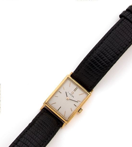 OMEGA
Montre de dame en or 18K (750), cadran rectangulaire, fond satiné, index batons, mouvement mécanique, bracelet en cuir, boucle métal. 
Poids brut : 22,9 g 