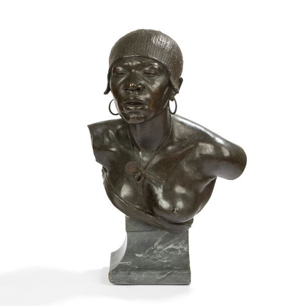 GIOVANNI BATTISTA FRANCESCO FASCE (1858-1902
Buste d’africaine, probablement celui d’une femme Hamer (Éthiopie), le modèle créé vers [1890/95]
Sculpture.
Épreuve en bronze à patine noire.
Fonte à la cire perdue d’édition ancienne.
Base en marbre gris veiné.
Signée FASCE G. B. et porte le cachet de fondeur L. GATTI fuse sur l’arrière.
Hauteur bronze seul : 51 cm
Hauteur totale : 69 cm

Artiste génois, Fasce est l’élève du sculpteur Lorenzo Orengo. Également peintre décorateur, il reçoit en 1892 une médaille d’argent à l’Exposition Nationale de Palerme pour deux sculptures historiques. Dans cette thématique, on lui doit une statue de Guillaume Tell pour le théâtre Carlo Felice de Gênes. Il réalise aussi, après avoir remporté le concours en 1896, un important monument à Nicola Fabrizi pour la ville de Modène. Il se distingue également dans l’art funéraire en réalisant le tombeau de Balestrino en 1900 au cimetière Staglieno de Gênes et le monument à Leandri au cimetière Verano de Rome. La Galleria il Chiostro à Gênes conserve dans ses collections une tête de bébé en terre cuite de l’artiste. Il décède en 1902 alors qu’il travaille à Rome sur les sculptures du fronton du palais Esedra place de la République.

L’art de Fasce révèle sa sensibilité et son sens aigu de l’observation et du détail. Malgré tout, la connaissance de son œuvre avait, jusqu’à maintenant, livré une expression dans la pure veine des grands et bons sculpteurs italiens de la fin du XIXe siècle.
Notre buste d’africaine laisse apparaitre une facette bien méconnue de l’artiste.
En effet, à travers cette sculpture, fort de sa maturité, Fasce explore une nouvelle manière avec une très grande réussite et prend une voie audacieuse qui le conduit à une œuvre majeure. À une époque où le colonialisme bat son plein, le sculpteur approche son sujet avec empathie et sans voyeurisme, rarement un regard sculpté aura eu une telle intensité, ni avant