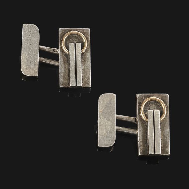 JEAN DESPRÉS (1889-1980)
Rare paire de boutons de manchette modernistes en argent et or.
Les platines au motif d’une double barrette retenant un anneau sur un fond traité en martelage.
Chaque bouton signé J. DESPRÉS à la pointe et porte les poinçons de Maître Orfèvre et de garantie.
Poids : 15,4 g
Provenance :
- M. et Mme X., Avallon. Œuvre acquise directement auprès de Jean Després.
- Mme D., Sarzeau (Bretagne). Fille des précédents.