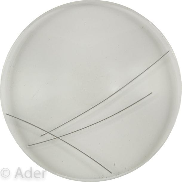 Marta PAN [franco-hongroise] (1923-2008)
Lentille 500, 1970
Sculpture en plexiglas et acier inoxydable.
Monogrammée et numérotée « 2 » sur la tranche.
(Petites rayures sous la base).
Diamètre : 51 cm

Provenance : 
Galerie Jean-Robert Arnaud, Paris.

Exposition : 
Marta Pan, Galerie Jean-Robert Arnaud, Paris, 1971, reproduit au catalogue.

L’œuvre est référencée dans le Catalogue Raisonné de l’œuvre de Marta Pan sous le n°115.
Notre sculpture est l’exemplaire n°2 d’une réalisation prévue à 3 exemplaires. L’exemplaire n°1 a été acquis par une collection privée californienne et présenté lors de deux expositions personnelles de Marta Pan à la Wenger Gallery de San Francisco en 1970 et à l’University of Southern California à Los Angeles en 1972. L’exemplaire n°3 n’aurait pas été réalisé.
Entre 1967 et 1975 Marta Pan crée plus de quatre-vingts sculptures en plexiglas. 
Elle y transpose d’abord dans des œuvres de petites dimensions ses recherches sur les « puzzles » abordées dans ses œuvres en bois. 
Puis, au cœur de la masse totalement transparente de lentilles, de cylindres, de sphères, de cubes, elle dispose ce qu’elle nomme « ses architectures », formes géométriques qui se révèlent sous l’action de la lumière. 
Enfin, dans des cônes ou des lentilles de grandes dimensions (entre 40 et 50 centimètres de diamètre), elle intègre des tubes contenant du mercure ou des billes de bois, afin d’intégrer le mouvement ou des tensions visuelles au cœur même de la matière inerte, prolongeant par là le mouvement potentiel intégré à ses premières sculptures en bois qui la conduiront à « inventer » les sculptures flottantes.

Nous remercions Monsieur Dominique Amouroux, directeur de la Fondation Marta Pan - André Wogenscky, pour les informations qu’il nous a transmises.