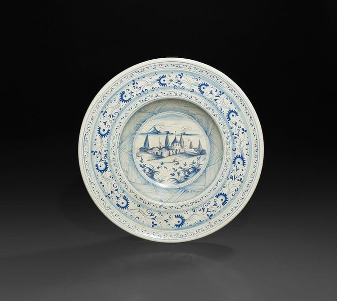 Italie
Grand plat rond à décor en camaïeu bleu au centre d’un village et sur l’aile de fleurs stylisées.
D?: 46?cm 