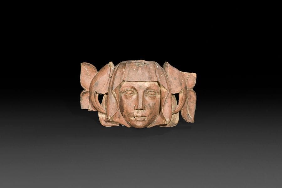 Tête de femme sculptée en fort relief en résineux monochromé. Visage encadré d’un voile entouré de rinceaux feuillagés.
XVIe siècle
H?: 15,5?cm, L?: 26,2?cm
(petits manque, trous de suspensions) 
 