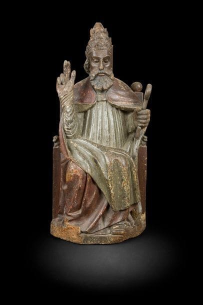 Nord de la France ou Pays-Bas méridionaux, XVIe siècle
Le pape saint Pierre trônant
Ronde-bosse en chêne polychromé
H?: 91?cm
Anciennes restaurations (main droite et clé rapportée), accidents et manques, usures de la
polychromie.

 Le prince des apôtres, coiffé de la tiare pontificale et revêtu de la chape, est représenté en majesté, assis sur une cathèdre imposante aux pommeaux en forme de lions. Il bénit de la main droite et tient de la main gauche une imposante clé, principal attribut du saint rappelant son rôle de guide des élus au Paradis, et dans ce contexte institutionnel, son rôle d’incarnation de l’Église romaine. Apparue dès le XIVe siècle dans les Pays-Bas méridionaux, cette iconographie de saint Pierre en chef de file de l’Église s’est largement répandue au XVIe siècle.