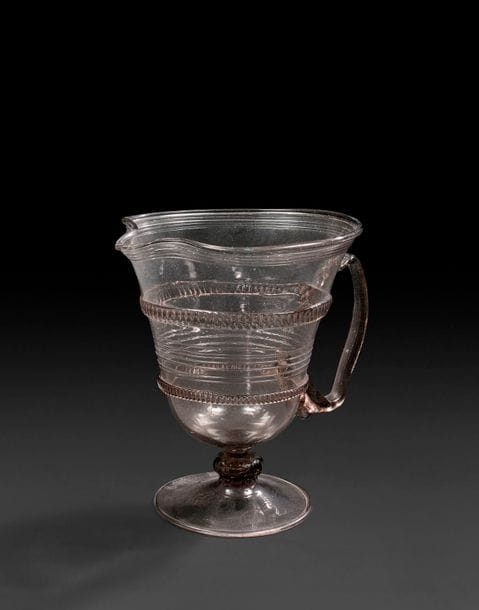 Aiguière en verre fumé, reposant sur un piédouche.
France, fin du XVIe siècle, début du XVIIe siècle.
H : 16 cm
 
Bibliographie :
S. Lhermite-King, Cent verres français, 1550-1750, Trésors des collections privées, Paris, 2018, n°37.