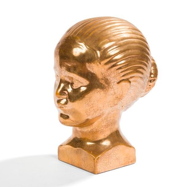 LOUIS HENRI NICOT (1878-1844)
Tête de jeune femme au chignon
Sculpture en céramique émaillée or et craquelée. Circa 1930. Petit éclat sur l’arête arrière de la terrasse. H. 23,5 cm