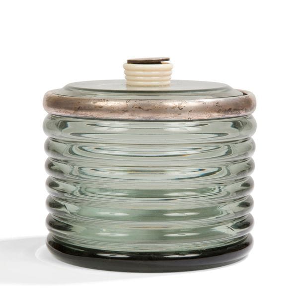 TRAVAIL 1930
Pot couvert en cristal fumé cerclé d'argent. La prise en ivoire ; la pastille chiffrée en métal argenté.
Le cerclage porte le poiçon de garantie.
T. D.. H. 13 cm – D. 15 cm