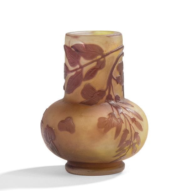 ÉTABLISSEMENTS GALLÉ (1904-1936) 
Glycine
Vase oignon ; la panse bulbeuse, le col cylindrique. Épreuve en verre multicouche au décor, dégagé à l’acide, traité prune sur fond jaune. Une bulle vers la col. Signé GALLÉ, en réserve gravé en camée à l’acide. H. 9 cm 