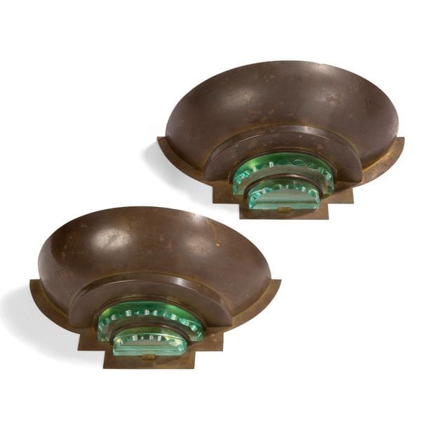 ANNÉES 1930/40
Paire d’appliques demi-circulaires aux bases à gradins. Épreuves en laiton patiné ; ornement de disques de verre taillé. H. 13 cm – L. 32,5 cm