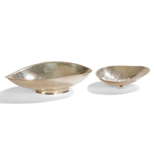 TAPIO WIRKKALA (1915-1995) 
Réunion de deux coupes en argent. Une en forme de feuille sur talon, l’autre en forme de coquillage sur trois pieds boules. Déformations sur les bordures. Chacune porte le monogramme de l’artiste et les poinçons de garantie. 
L. 20 et 13 cm. Poids total : 252 g