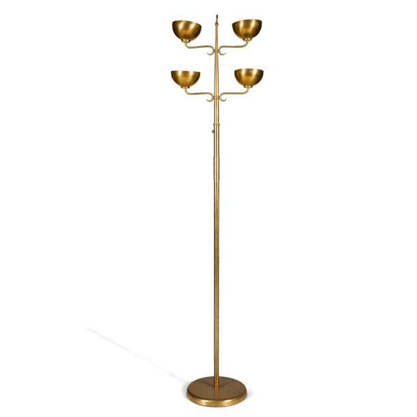 TRAVAIL ITALIEN 1940/50
Lampadaire à quatre lumières en laiton doré. Le fût tronconique achevé par un anneau reçoit les quatre bras de lumière en volutes et terminés par des coupelles hémisphériques. Base circulaire. Altérations à la patine et enfoncements sur la base. H. 190 cm
