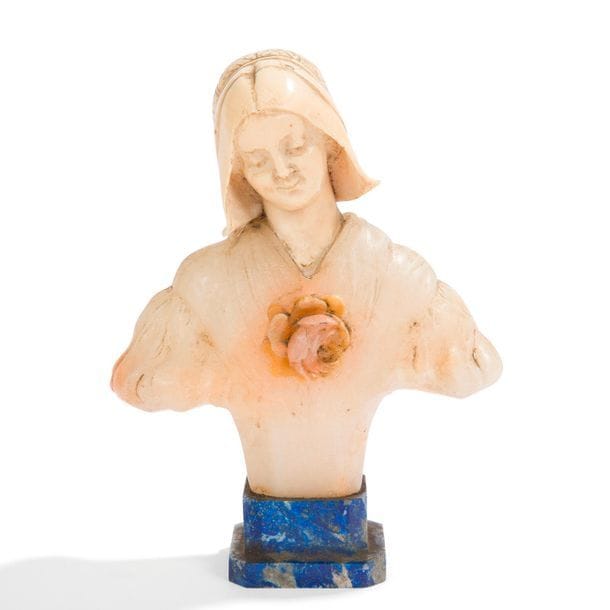 TRAVAIL FIN XIXe – DÉBUT XXe SIÈCLE
Femme médiévale à la rose 
Buste sculpté. Le visage et la coiffe en ivoire finement sculpté, le corps en albâtre et reposant sur un socle en lapis-lazuli. Signé PEY… au dos. H. 15 cm 