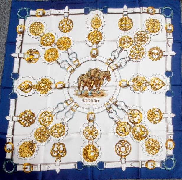 Carré HERMÈS, "Cuivreries", fond beige, entourage bleu roi. Signé F. de la Perrière.

(Bon état)