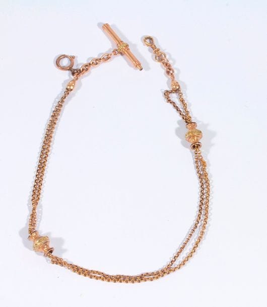 Chaîne giletière en or 18K (750), retenant une clé de montre et des coulants émaillés. Poids brut: 13,7 g