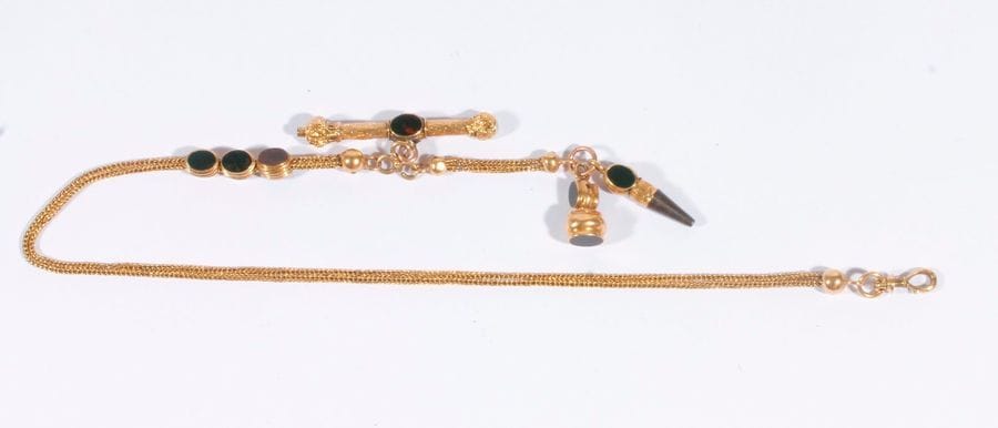 Chaîne de montre en or 18K (750) retenant une clé de montre et des pendentifs ciselés ornés de jaspe. Travail français de la fin du XIXe siècle. Poids brut: 18,6 g