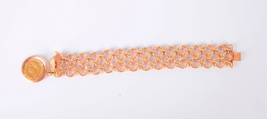 Bracelet large en or 18K (750), articulé d'anneaux, retenant en pampille mobile une pièce de 20 Francs or. Poids: 74 g